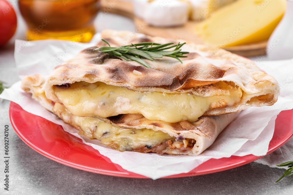 Tasty pizza calzones with cheese and rosemary on light grey table, closeup