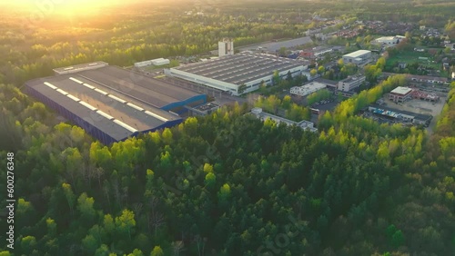 An industrial giant glows in the warmth of the setting sun. The aerial shot captures the magnitude of the building, surrounded by smaller structures.