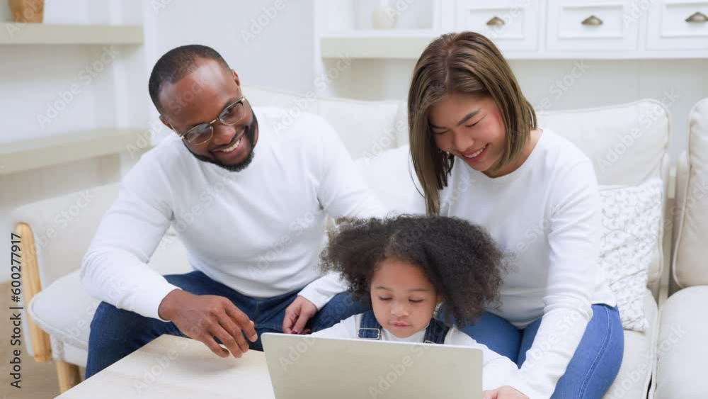 Happy african family parents and little children enjoy using computer laptop together sit on sofa, technology addicted couple with kids having fun at home Happy african family parents and little children enjoy using computer laptop together sit on sofa, technology addicted couple with kids having fun at home