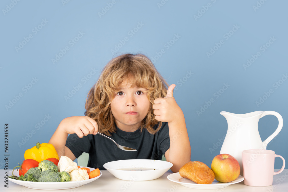 Kid eating soup. Hungry face and enjoy eating enjoy food concept. Funny kid with plate of soup. Kid eating soup. Hungry face and enjoy eating enjoy food concept. Funny kid with plate of soup.