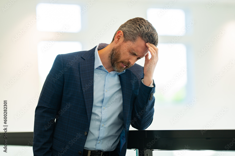Tired man having a terrible headache. Exhausted man feeling unhealthy, upset about headache illness. Closeup portrait of stressed middle-aged man having headache. Migraine and headache concept. Tired man having a terrible headache. Exhausted man feeling unhealthy, upset about headache illness. Closeup portrait of stressed middle-aged man having headache. Migraine and headache concept.