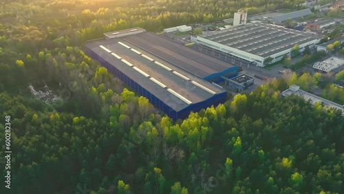 An industrial giant glows in the warmth of the setting sun. The aerial shot captures the magnitude of the building, surrounded by smaller structures.