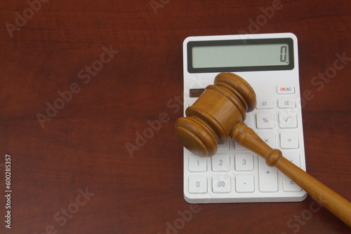 Wooden judge gavel and calculator on wooden table. Copy space for text. photo