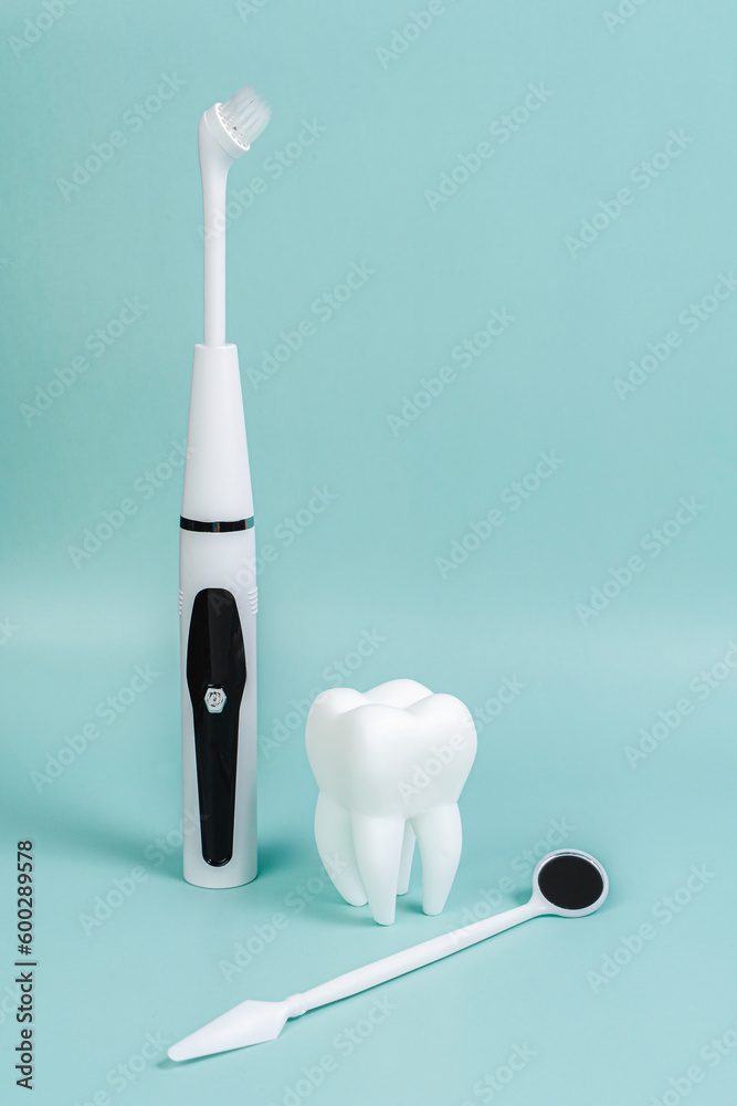 Dental treatment at the dentist. Removal of tartar. Caries treatment. White tooth on a blue background. advertising banner. Instruments for dental treatment. Mirror, toothbrush, irrigator