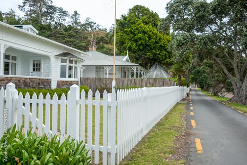 White picket fence along road past colonial buildings