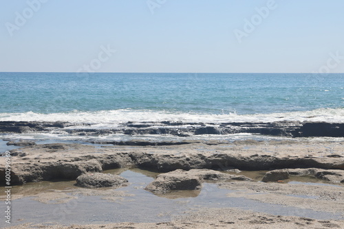 Fototapeta Naklejka Na Ścianę i Meble -  Rocky sea beach on a sunny day in Alanya, Turkiye, May 2023.
