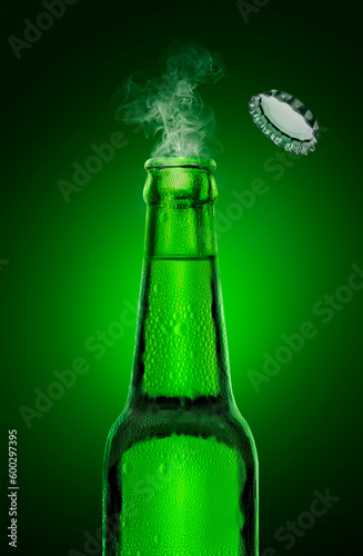 cold wet open beer bottle with smoke on green background