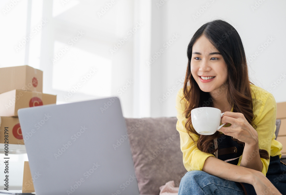 Young Women drinking coffee happy after new order from customer, business owner working at home office packaging on background. online shopping SME entrepreneur or freelance working concept. Young Women drinking coffee happy after new order from customer, business owner working at home office packaging on background. online shopping SME entrepreneur or freelance working concept.