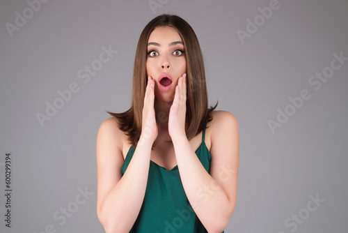 Girl raising eyebrows being surprised and shocked. Astonished reaction on unexpected news. Girl in t-shirt on isolated studio background with shocked, surprise and amazed expression on face.