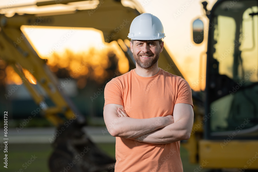 Builder, construction worker in helmet at construction site. Industry engineer worker in hardhat near bulldozer or digger tractor. Concept of construction industry. Construction site manager. Builder, construction worker in helmet at construction site. Industry engineer worker in hardhat near bulldozer or digger tractor. Concept of construction industry. Construction site manager.