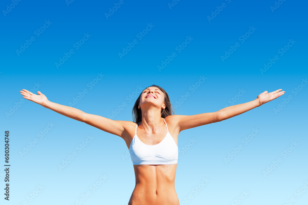 Freedom, woman and sunshine outdoor with happiness and calm feeling with open arms. Blue sky, mindfulness and female person with happy smile and healthy body from sun and celebrate life with wellness