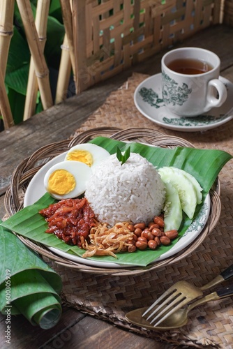 Asian cuisine Nasi Lemak is a rice dish infused with coconut milk. Served with sambal sauce, fried anchovies, fried peanuts, boiled eggs, and fresh cucumber.