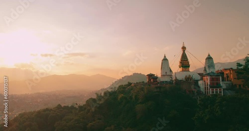 Gliding towards the Monkey Temple as the sun sets, our drone captures the majestic Swayambhunath Stupa in all its golden glory, a stunning sight amidst the peaceful landscape of Nepal.
