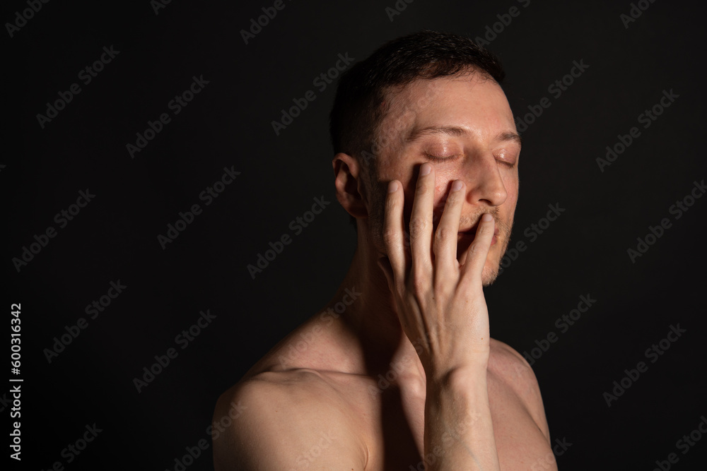 Young attractive man with an athletic body on a black background. Young attractive man with an athletic body on a black background.