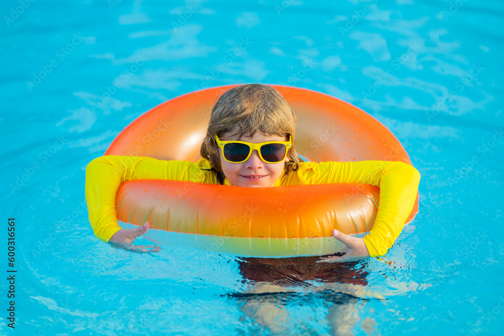 Summertime fun. Little kid swimming in pool. Kid in swimming pool relax and swim on inflatable ring. Summer vacation concept. Summer vacation.