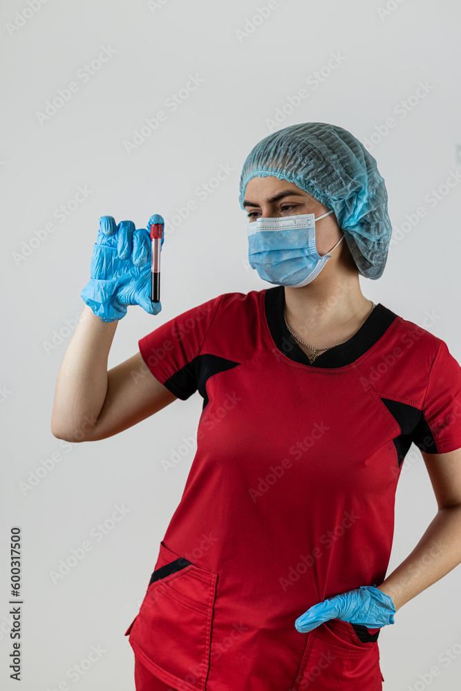 © RomanR - woman doctor wear red uniform, mask protection and gloves hold test tube with blood sample