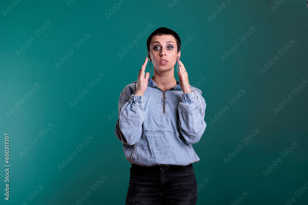 Angry unhappy young adult having agressive emotion wanting to screem while posing in studio standing over isolated background. Stressed worried caucasian female having mental breakdown