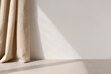 Neutral modern empty room with sunlight shadow, white blank wall background, beige linen curtain and stone floor or tabletop, aesthetic minimalist interior design template