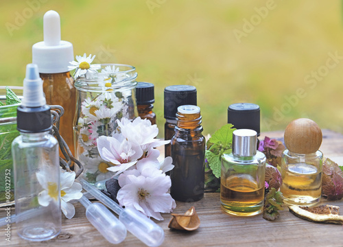 bottles of essential oil with plant and flower and aromatherapy equipment on ...