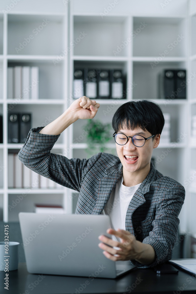 Young asian businessman are excited business success with inspiration from their excellent financial results that are happy working in a modern office on a computer. Young asian businessman are excited business success with inspiration from their excellent financial results that are happy working in a modern office on a computer.