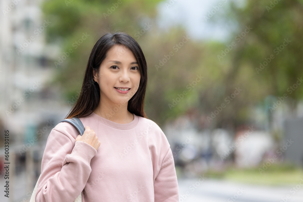 Woman smile to camera and stand on the street