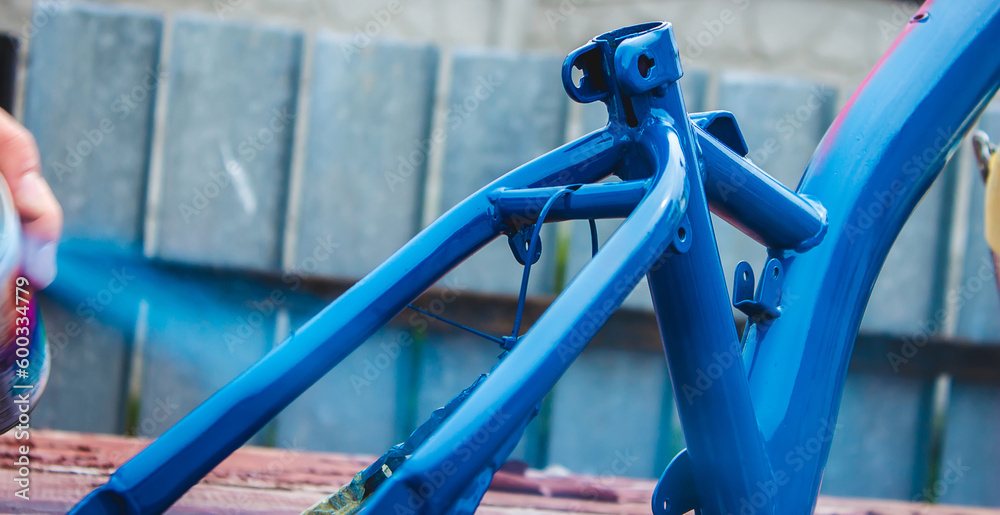 a man paints a bicycle with spray paint. a man paints a bicycle with spray paint.