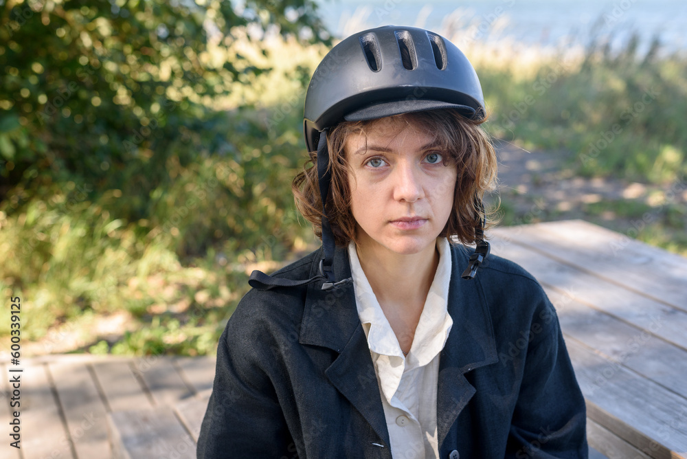 Young woman in bicycle helmet at park. Portrait