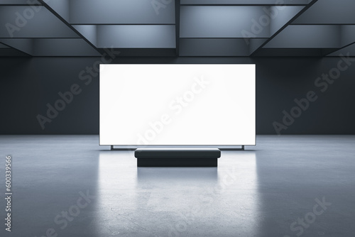 Fototapeta Naklejka Na Ścianę i Meble -  Front view on a bench on concrete floor in front of blank white illuminated screen with place for your logo or advertising text on dark wall background in modern exhibition hall. 3D rendering, mock up