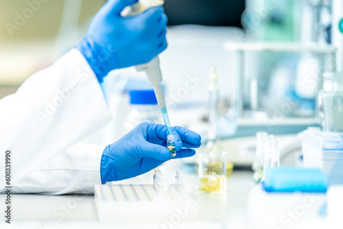 pipetting of chemical samples during research in a biochemical scientific laboratory