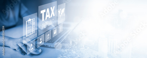 Hand using a laptop with TAX REFUND and refund tax of duty taxation business, graphs and chart being demonstrated on the screen media,  tablet pc and selecting tax refund, Saving tax for business