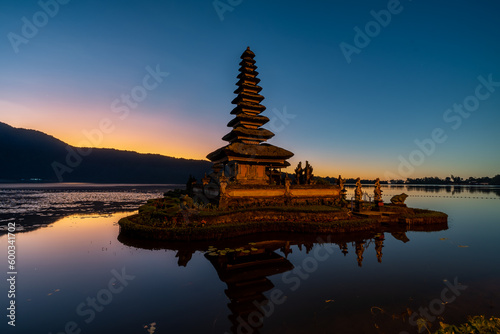 Hindu water temple in Bali, Pura Ulun Danu Bratan, features pagodas, gardens, lotus ponds, set against a backdrop of mist-shrouded mountains on Lake Bratan