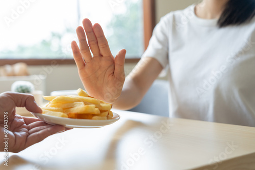 Beauty slim female body confuse French fries. Woman in restaurant achieves weight loss goal for healthy life, crazy about thinness, thin waist, nutritionist. Diet, body shape.