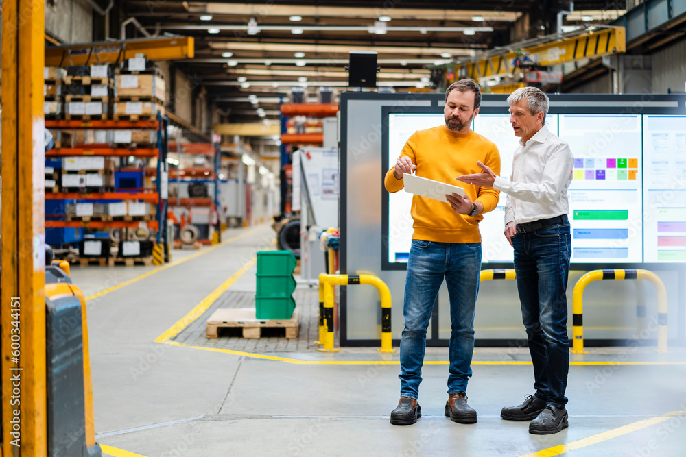 Mature businessman gesturing and having discussion in industry Mature businessman gesturing and having discussion in industry