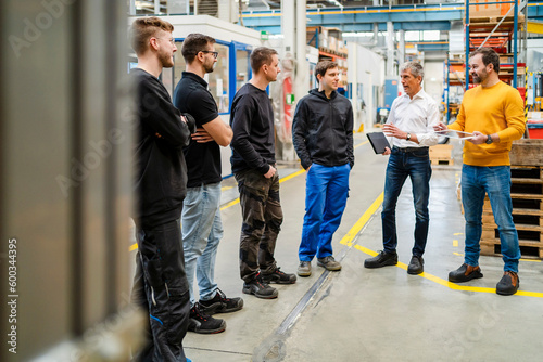 Businessman and manager conducting meeting with team at factory photo