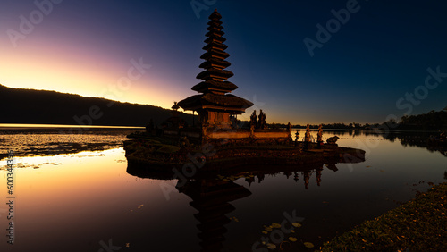 Hindu water temple in Bali, Pura Ulun Danu Bratan, features pagodas, gardens, lotus ponds, set against a backdrop of mist-shrouded mountains on Lake Bratan
