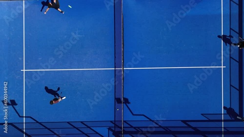Aerial top view shot of padel tennis players playing on the court in summer.