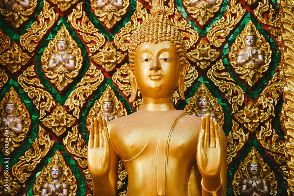 Close up of Buddha statue with beautiful details of Thai fine arts background at Buddhist temple.