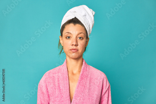 Freshly showered young caucasian woman in pink robe  studio photo.