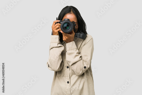 Young Indian photographer woman holding a professional camera isolated photo
