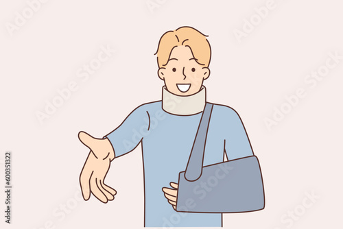 Smiling man with broken arm and bandage around neck extends hand to camera to thank treating doctor