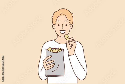 Man eats potato chips enjoying crispy high-calorie snack that quickly satisfies hunger