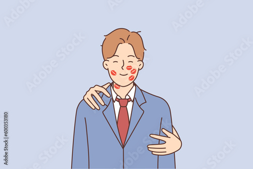 Romantic man with traces of lipstick on face and hands of woman hugging boyfriend from behind