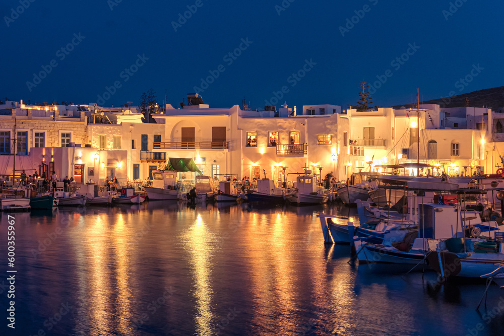 Traditional Greek fishing village and harbour after sunset, boats