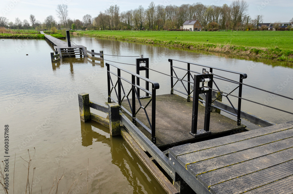 Schalkwijk, The Netherlands, April 8, 2023: tiny ferryboat across a lake that asks for a little physical exercise from its passengers