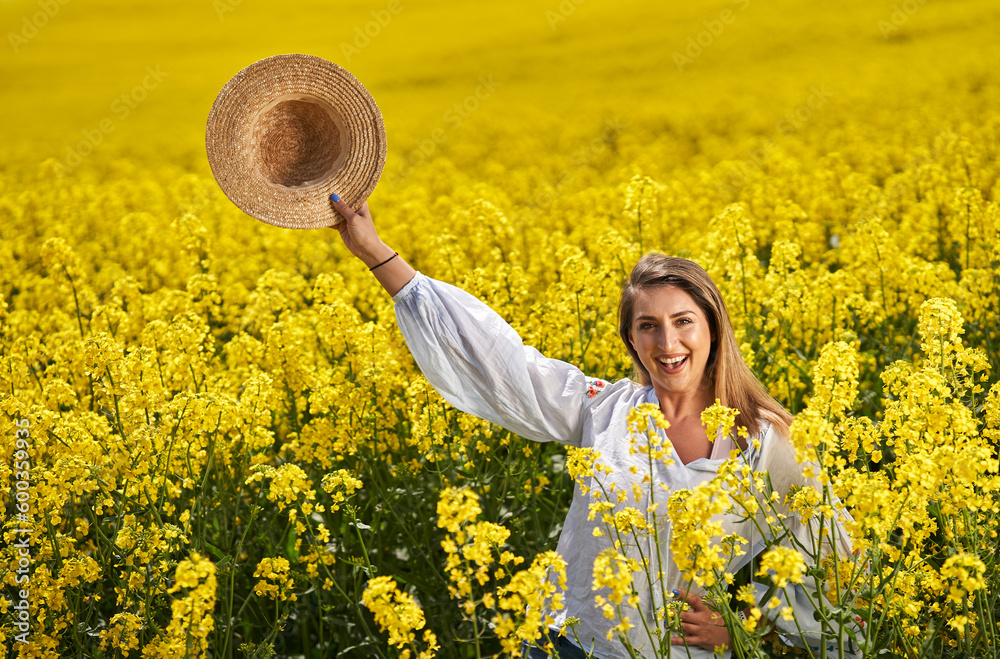 Fototapeta premium Beautiful blonde latino woman in a canola field