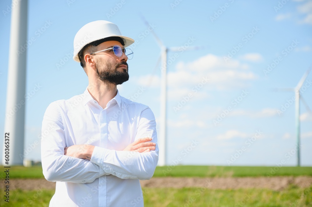 Engineer is checking energy production on wind turbine. Worker in windmills park Engineer is checking energy production on wind turbine. Worker in windmills park