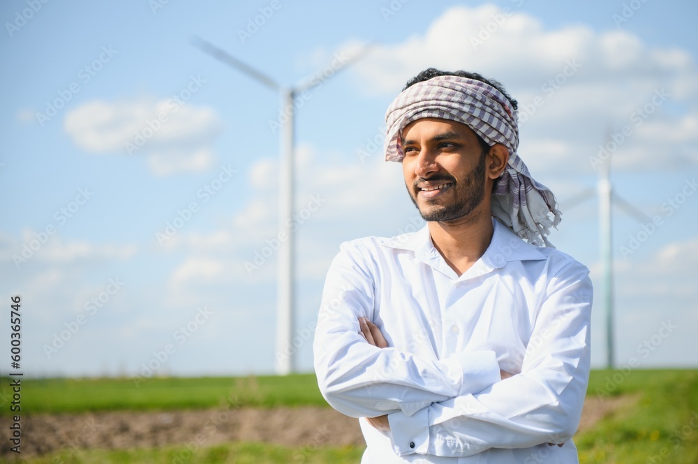 Indian Engineer working at alternative renewable wind energy farm - Sustainable energy industry concept Indian Engineer working at alternative renewable wind energy farm - Sustainable energy industry concept