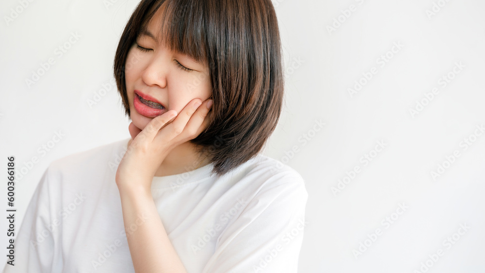 Woman showing a pained face because of a decayed tooth. Woman showing a pained face because of a decayed tooth.