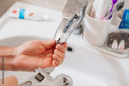 A plumber repairs or installs a faucet faucet in the bathroom