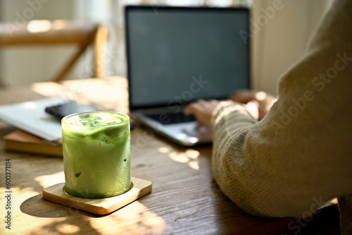 Konstfotografi Close-up image of a glass of iced matcha green tea on a wooden table in a minima